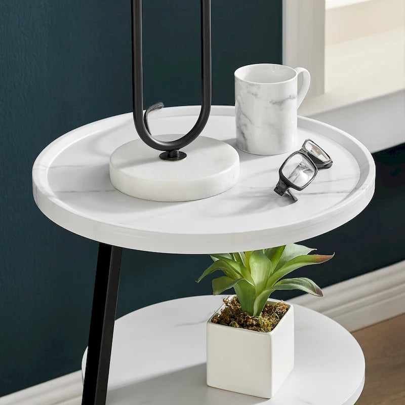 Mesa auxiliar redonda de tres niveles en blanco y negro con patas metálicas asimétricas