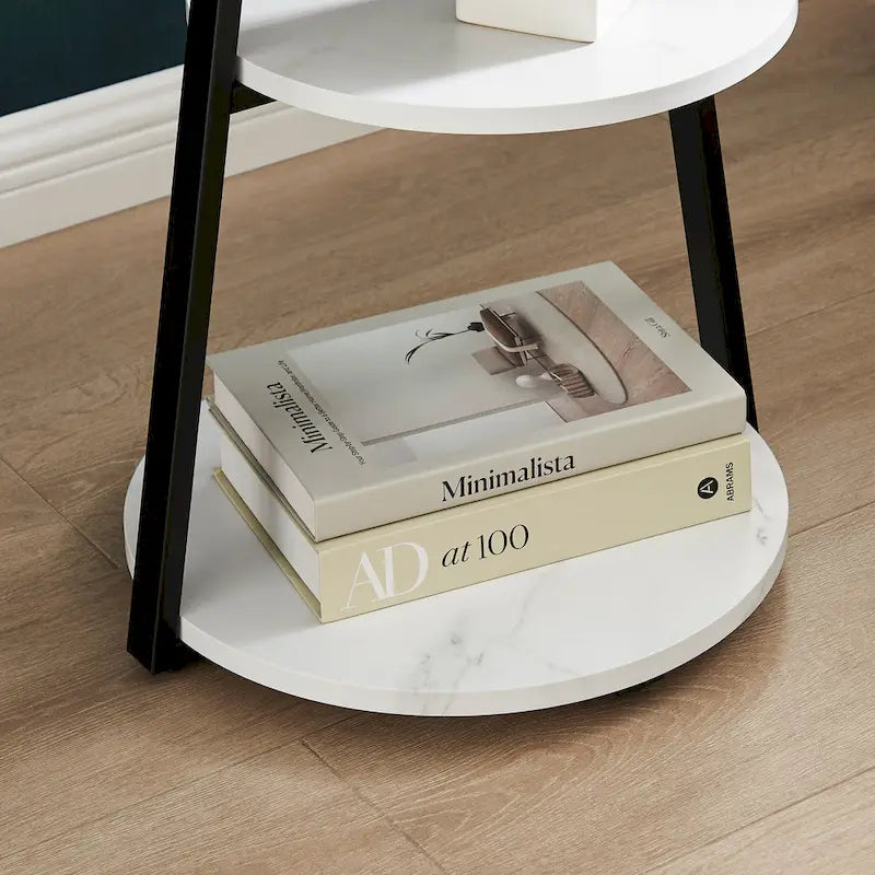 Mesa auxiliar redonda de tres niveles en blanco y negro con patas metálicas asimétricas