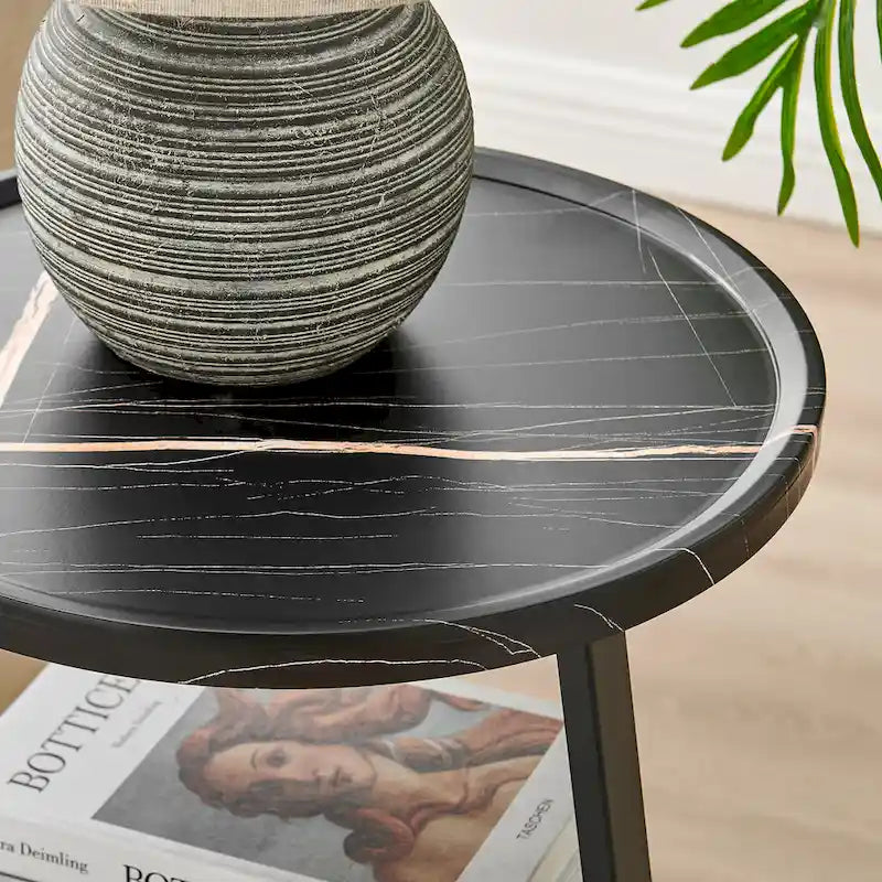 Mesa auxiliar redonda de tres niveles en blanco y negro con patas metálicas asimétricas